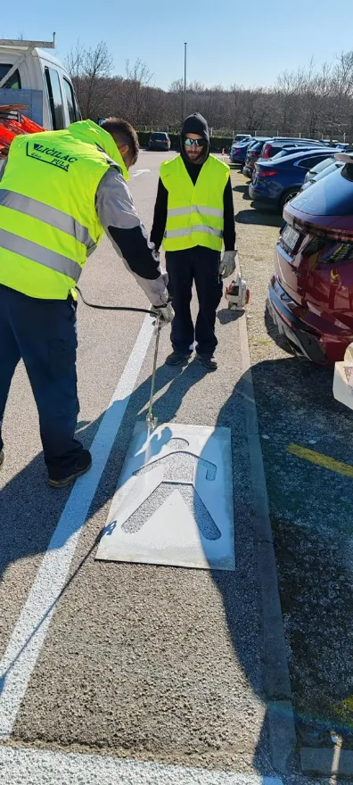 Djelatnici tvrtke Ličilac d.o.o. koriste šablonu i strojni pištolj za precizno iscrtavanje simbola pješaka