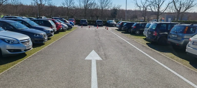 Dugačka bijela strelica za usmjeravanje prometa prema izlazu s parkirališta