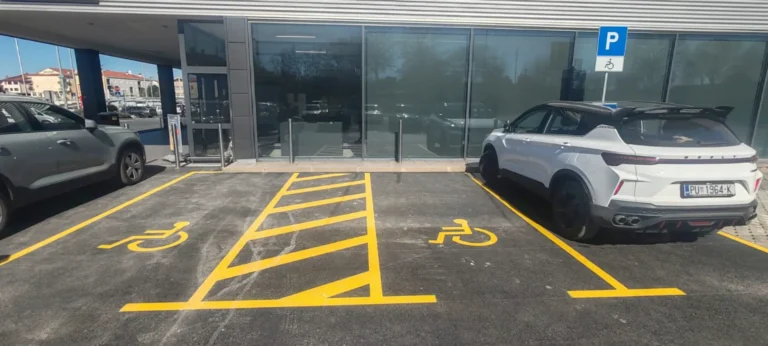 Detaljan prikaz žutih parkirnih mjesta za invalide s kosim linijama upozorenja
