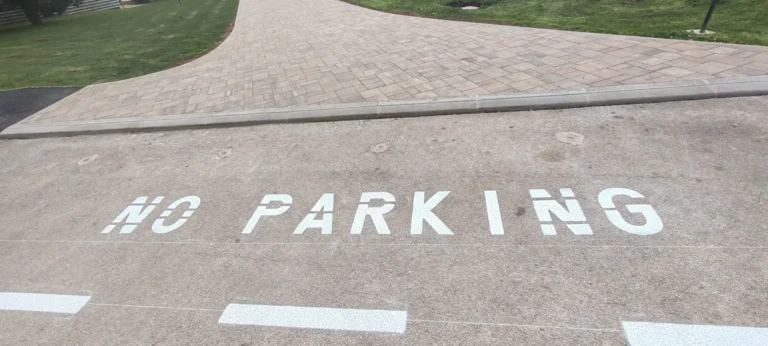 Veliki bijeli natpis NO PARKING iscrtan na betonskoj površini
