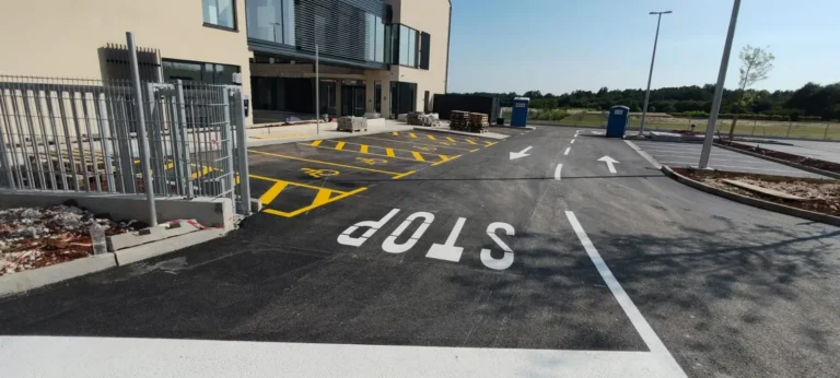 Iscrtana horizontalna signalizacija s natpisom STOP i žutim parkirnim mjestima za invalide ispred centra u Barbanu