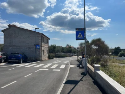 Detalj svjetlosne signalizacije iznad pješačkog prijelaza koja upozorava vozače na pješake.