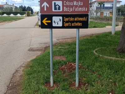 Vertikalna signalizacija s oznakama za crkvu i sportske aktivnosti montirana na pocinčane stupove