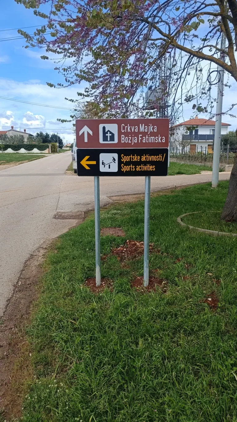 Vertikalna signalizacija s oznakama za crkvu i sportske aktivnosti montirana na pocinčane stupove